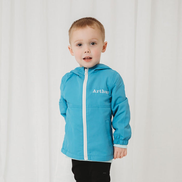 Lightweight personalised rain coat in blue, zip-up hooded toddler jacket with hem cuff.