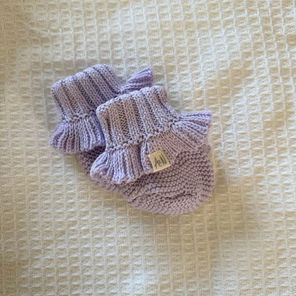 Lilac knitted baby booties, frilled ankle cuffs and small leather label