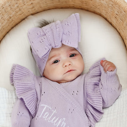 Lilac pointelle bow headband worn on a baby; ribbed bow loops