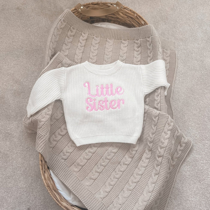 Personalised knitted child jumper in cream with pink 'Little Sister' text on gray knit