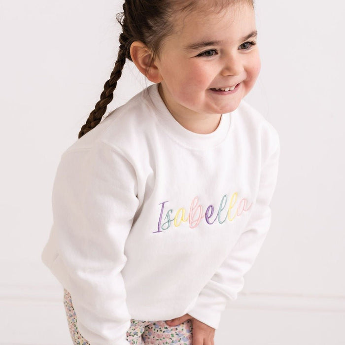 White sweatshirt with multicolor embroidered name Isabela on front, long sleeves