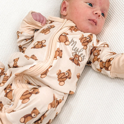 Baby zip sleepsuit with teddy bear print, zip front and long sleeves on infant.