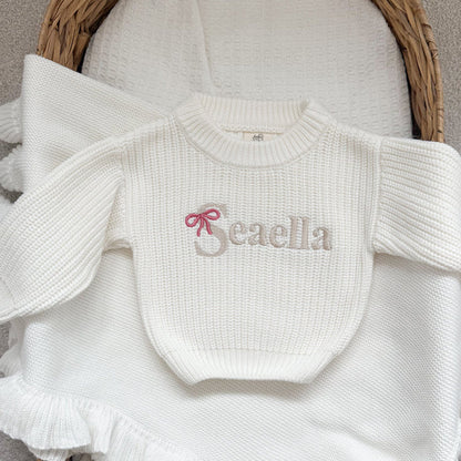 White chunky knitted jumper with 'Beaella' bow-name logo and ruffle hem