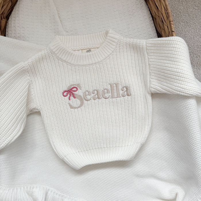 White knitted jumper with 'Beaella' bow-name logo and textured crew neckline