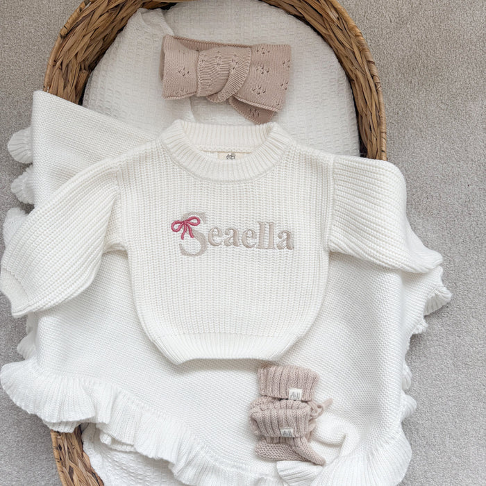 White chunky knitted jumper with ruffle sleeves and hem, front 'Beaella' logo