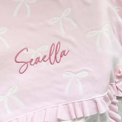 Personalised bow reversible blanket, close-up pink fabric with Seavella name and bow motif