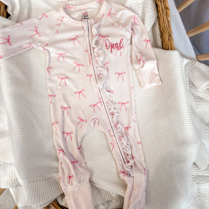 White ribbed zip sleepsuit with pink bow pattern and 'Opal' front print, zip opening