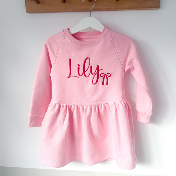 Pink long-sleeve dress with gathered skirt hem and 'Lily' print on front