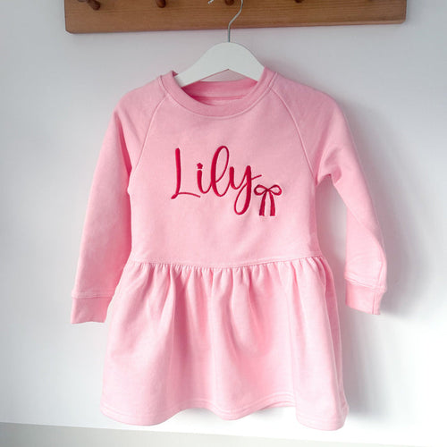 Pink long-sleeve dress with gathered skirt hem and 'Lily' print on front