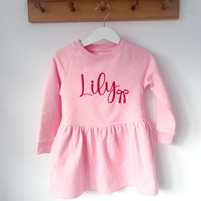 Pink long-sleeve dress with crew neck, gathered skirt, and 'Lily' print
