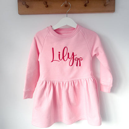 Pink long-sleeve dress with crew neck, gathered skirt, and 'Lily' print