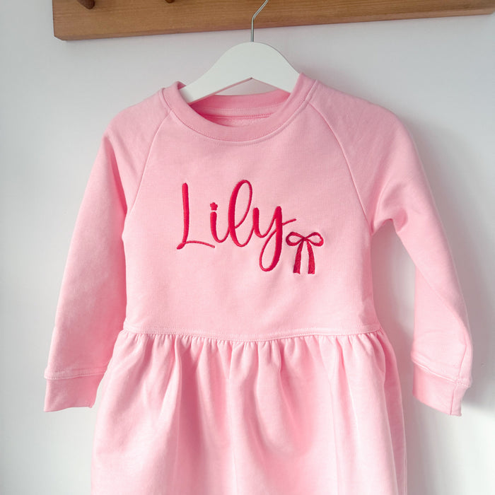 Pink long-sleeve toddler dress with 'Lily' lettering and bow graphic