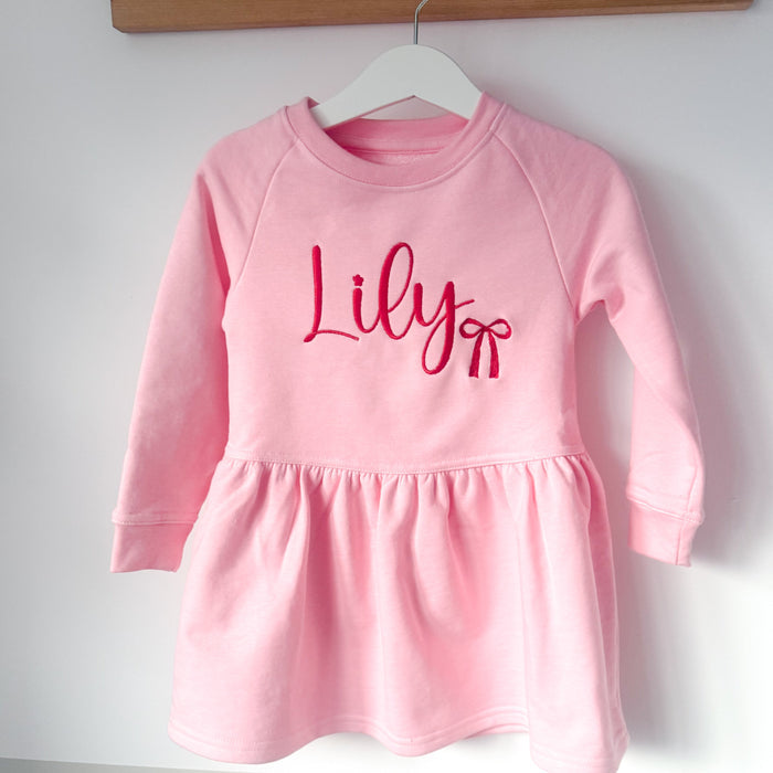 Pink long-sleeve dress with gathered skirt and 'Lily' logo center front