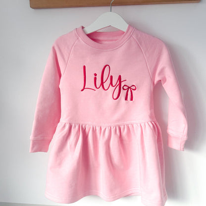 Pink long-sleeve dress with gathered skirt and 'Lily' logo center front