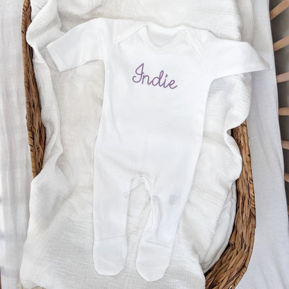 White long-sleeve sleepsuit with embroidered “Indie” front and footed legs
