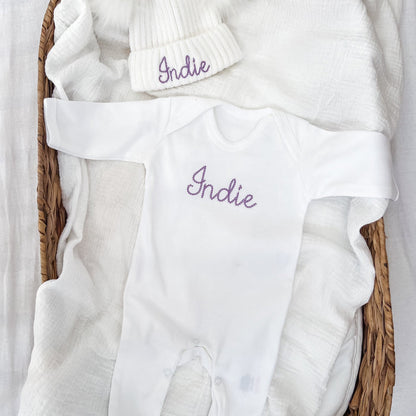 White sleepsuit with embroidered “Indie” plus matching ribbed beanie hat