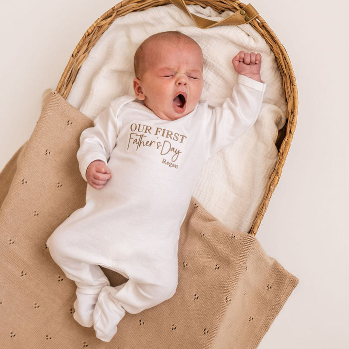 White baby sleepsuit with long sleeves, 'Our First Father's Day' print and Regan name