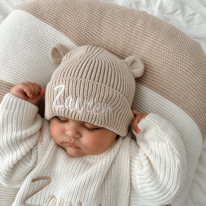 Cream knitted baby hat with bear-ear sides and embroidered name front