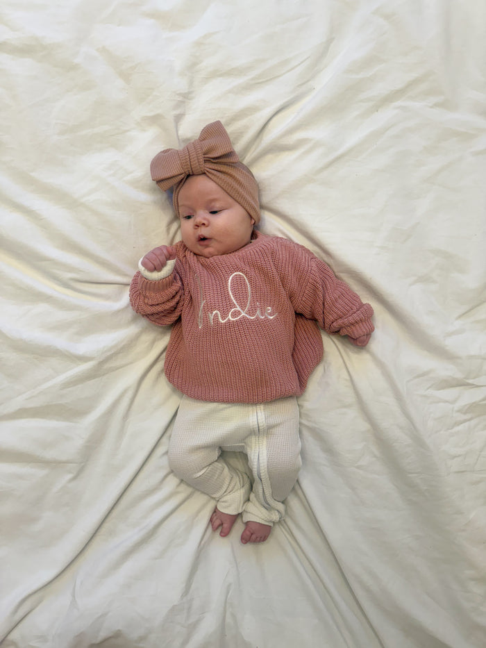 Personalised knitted jumper in dusty pink with 'Indie' script on the chest