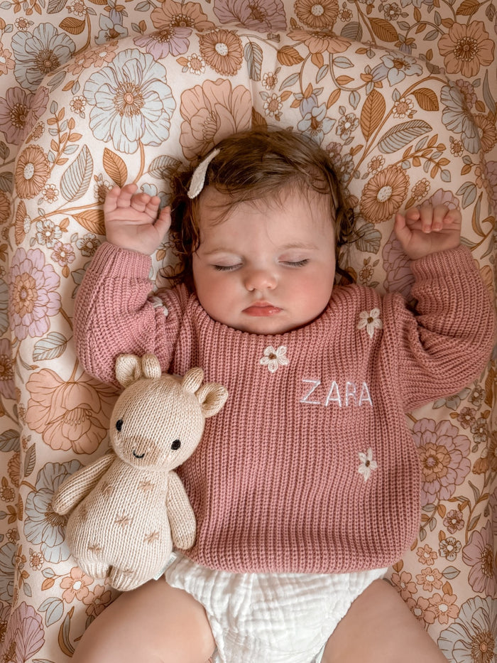 Pink knitted jumper close-up with small white motifs and ZARA logo