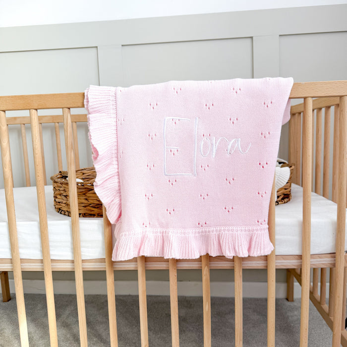 Pink pointelle knit blanket with ruffled frill border and stitched personalised name