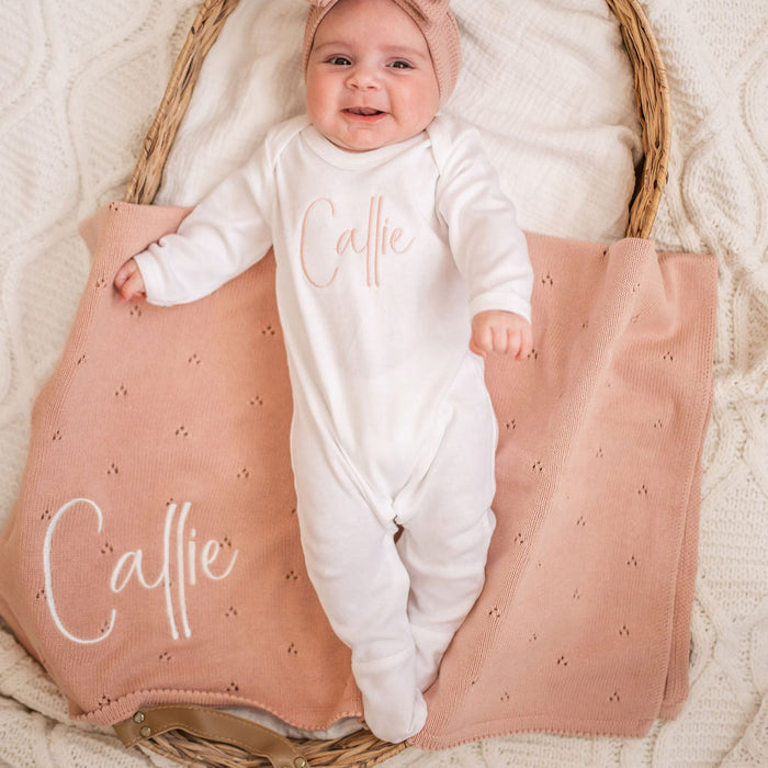 Personalized baby knit blanket in use, pink pointelle with 'Calle' name