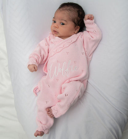 Pink pointelle kimono romper with ruffled collar, lace trim, and embroidered name on baby.