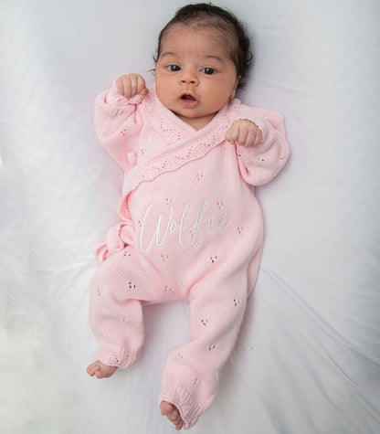 Pink pointelle kimono romper with ruffled cuffs and embroidered name on baby.
