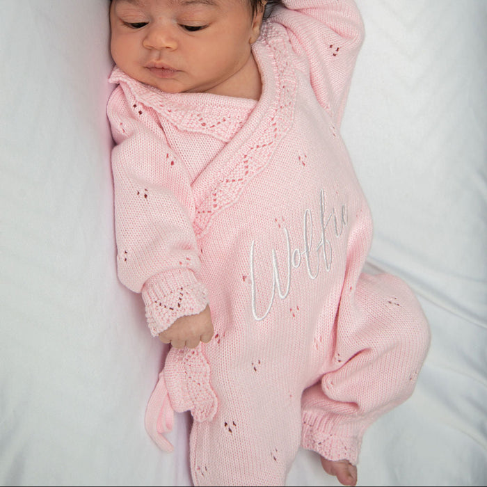 Pink pointelle kimono romper with ruffled collar and embroidered name on baby.