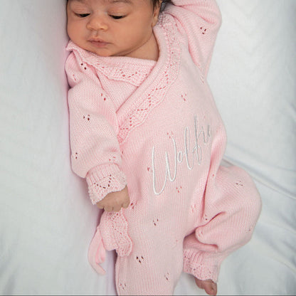 Pink pointelle kimono romper with ruffled collar and embroidered name on baby.