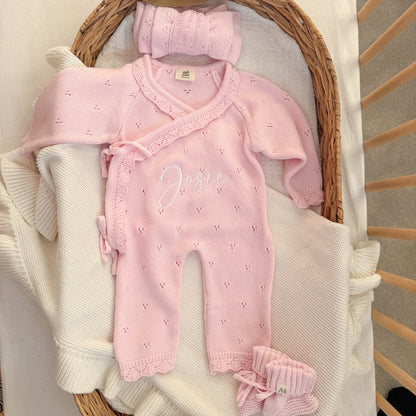 Pink pointelle kimono romper with lace trim, ruffled cuffs, and embroidered name.