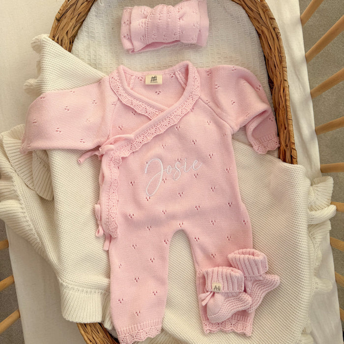 Pink pointelle kimono romper with lace cross-over, ruffled cuffs, and embroidered name.