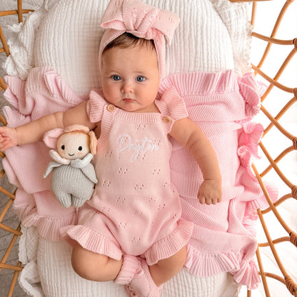 Pink pointelle summer romper with bow headband and plush bunny beside the baby