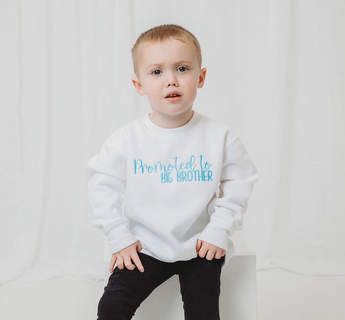 White sweatshirt with 'Promoted to BIG BROTHER' printed in blue lettering