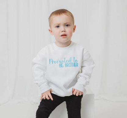 White sweatshirt with 'Promoted to BIG BROTHER' printed in blue lettering