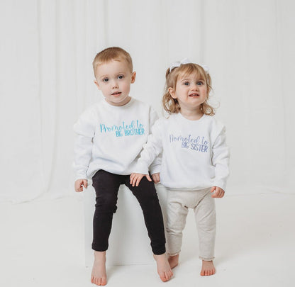 Matching white sweatshirts: 'Promoted to BIG BROTHER' and 'Promoted to BIG SISTER'