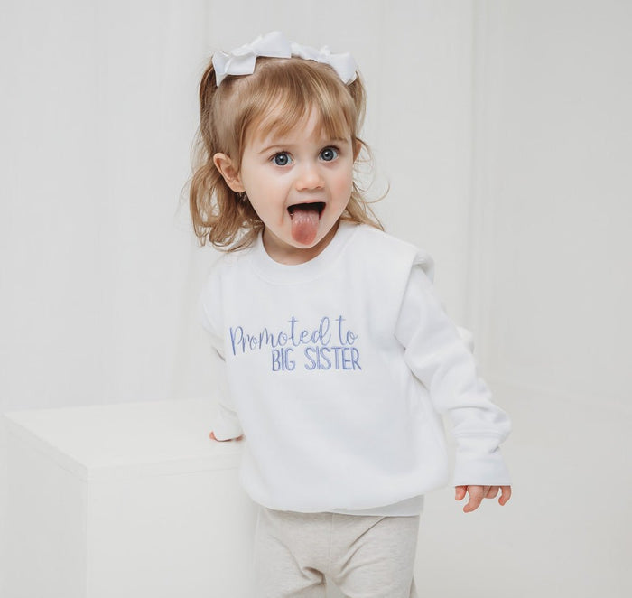 White kids sweater with "Promoted to BIG SISTER" print, long sleeves