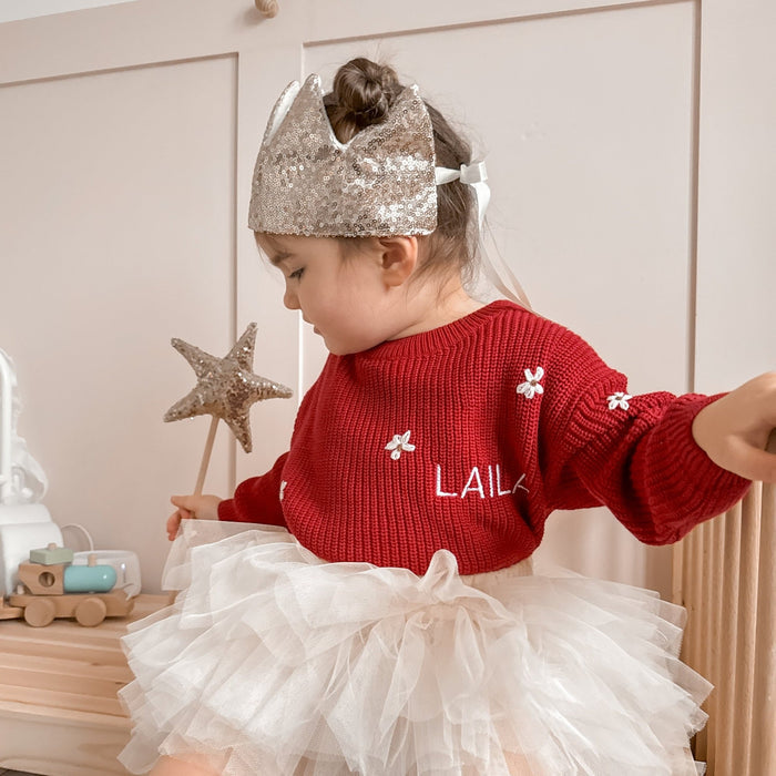 Red knitted jumper with white floral motifs and LAILA lettering, crew neck