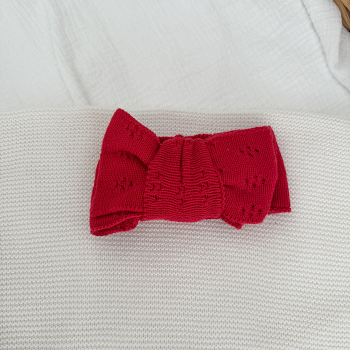 Red knit bow headband with ribbed center knot, pointelle sides