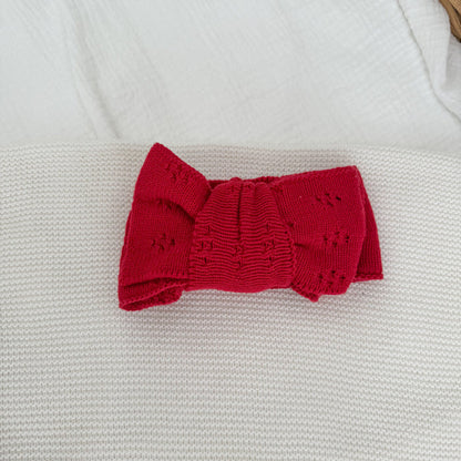 Red knit bow headband with ribbed center knot, pointelle sides