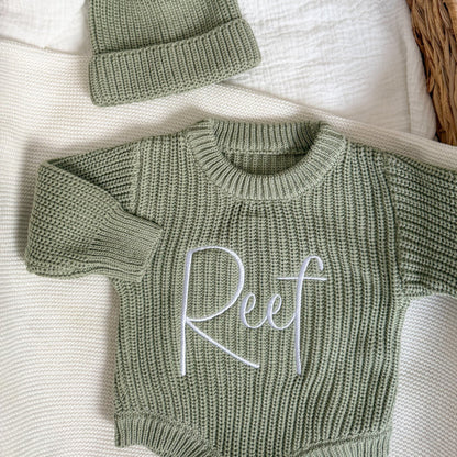 Sage green knit romper with long sleeves and embroidered cursive name on chest