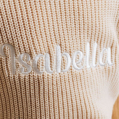 Beige knitted jumper with raised applique name "Sandbelle" across chest