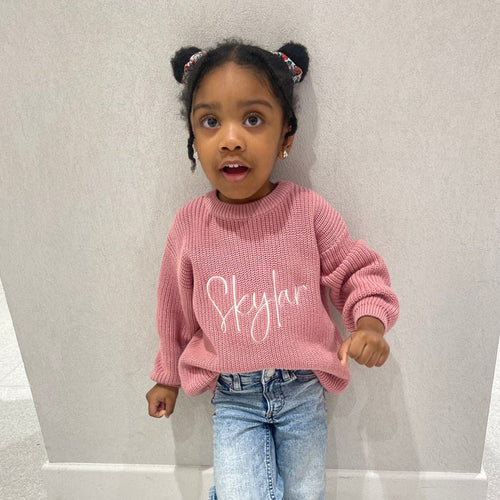 Pink knitted jumper with white script print at chest, crew neck, long sleeves