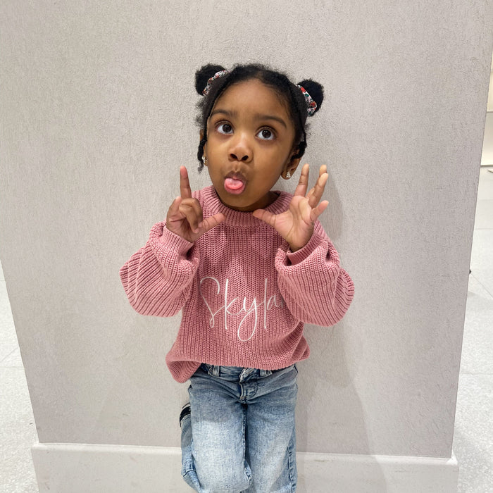 Pink knitted jumper with white script print, crew neck, long sleeves with ribbed cuffs