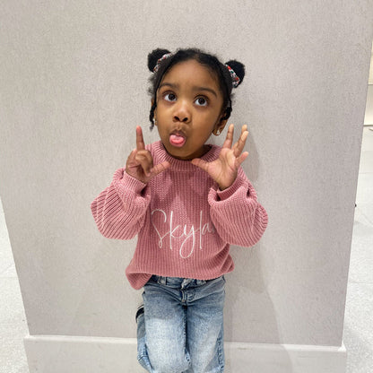 Pink knitted jumper with white script print, crew neck, long sleeves with ribbed cuffs