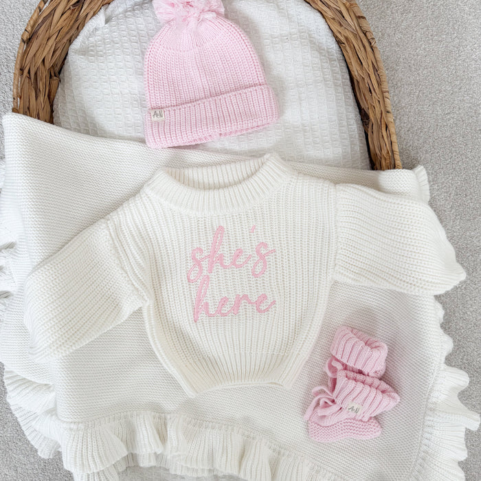 White chunky knitted jumper with pink script logo, ribbed crew neck, ruffled sleeve ends