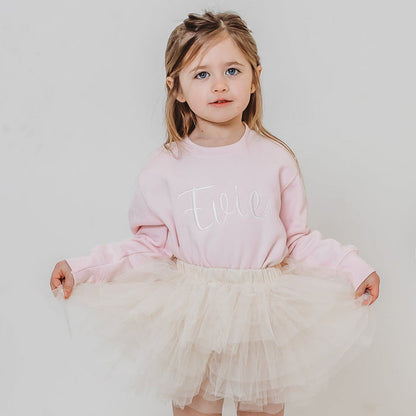 Light pink embroidered sweater with tulle skirt overlay and script chest design