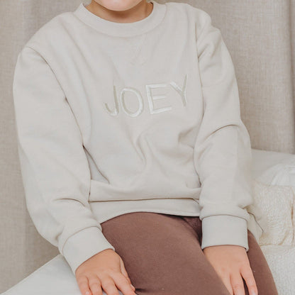 Light stone crewneck sweater close-up with long sleeves and JOEY embroidery