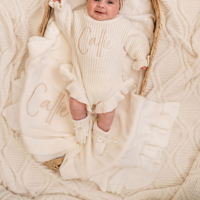 Personalized frill baby blanket with ruffled edge and 'Callie' embroidery, draped