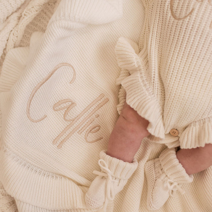 Personalized frill baby blanket with 'Callie' embroidery and cream knit texture